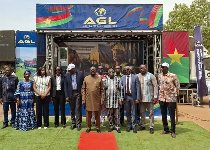 Group of people standing in front of an AGL-branded stage at the launch of the AGL Moving Tour Burkina 2026.